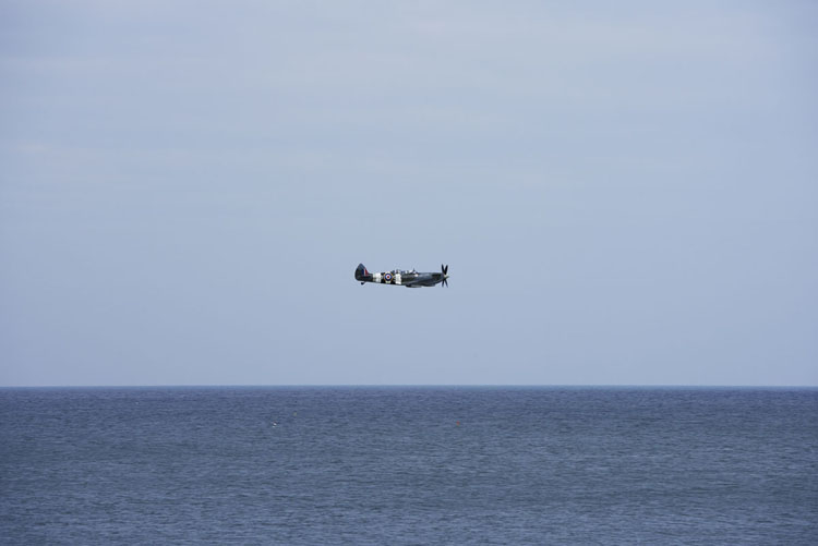 A Spitfire fighter plane over the sea in Cromer, Norfolk