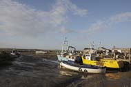 Fishing boats in the mud, low tide, Brancaster Staithe, Norfolk